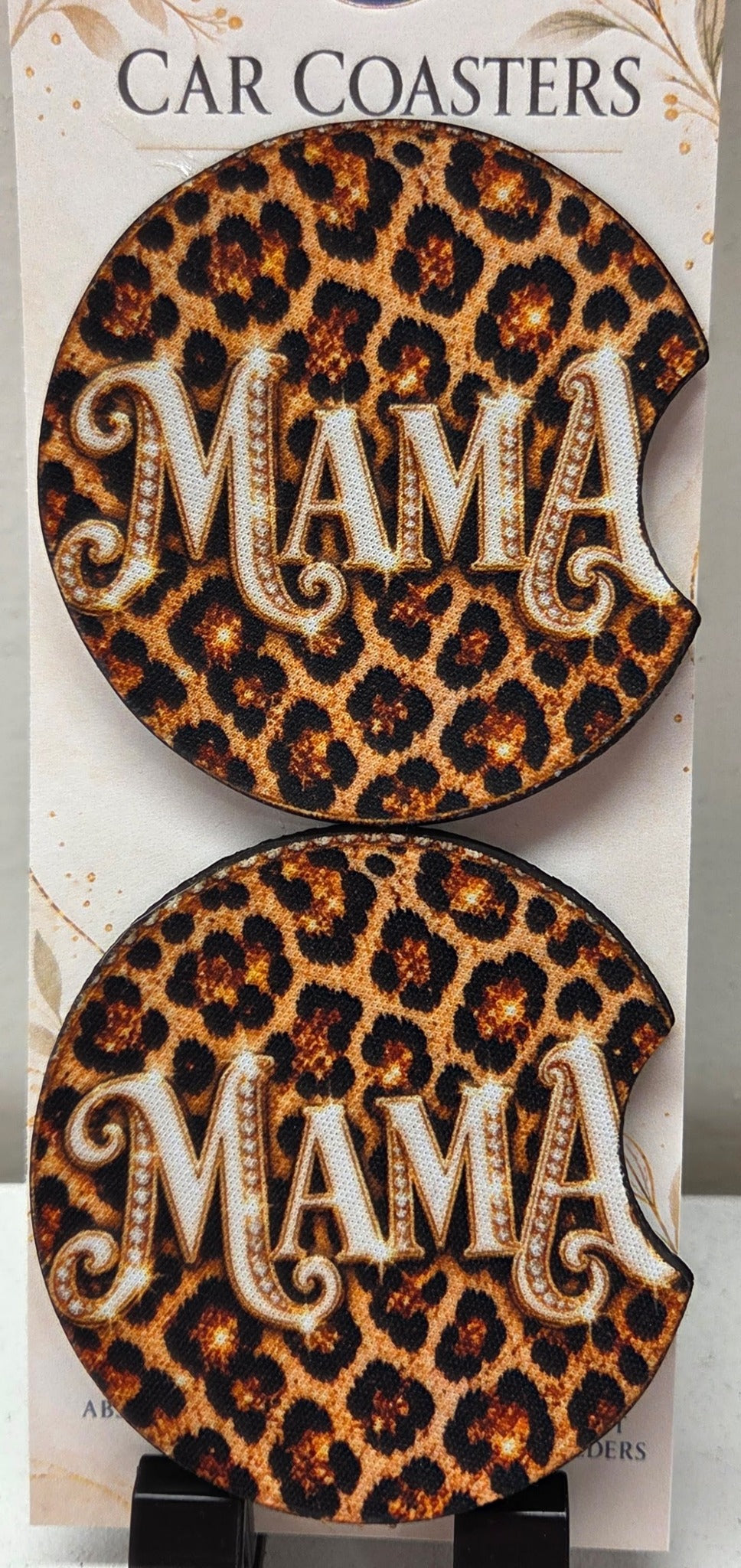 Real photo of two leopard print MAMA neoprene car coasters with finger notches