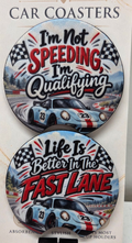Actual set of two racing-themed neoprene car coasters with finger notches and humorous racing phrases